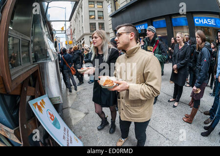 Des hordes d'amateurs queue à la Snowday chariot à New York le Mercredi, Décembre 17, 2014 pour célébrer la Journée nationale du sirop, le partenariat avec le sirop d'érable canadien, avec des échantillons gratuits de nombreux plats, y compris le sirop d'érable et au fromage de porc fumé-curseurs. Le camion alimentaire conscient socialement, partie de conduire le changement, exécute un programme utilisant l'anciennement incarcérées. (© Richard B. Levine) Banque D'Images