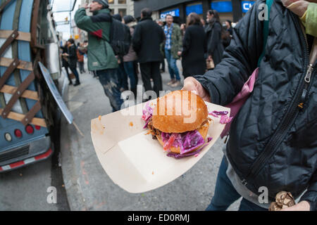 Des hordes d'amateurs queue à la Snowday chariot à New York le Mercredi, Décembre 17, 2014 pour célébrer la Journée nationale du sirop, le partenariat avec le sirop d'érable canadien, avec des échantillons gratuits de nombreux plats, y compris le sirop d'érable et au fromage de porc fumé-curseurs. Le camion alimentaire conscient socialement, partie de conduire le changement, exécute un programme utilisant l'anciennement incarcérées. (© Richard B. Levine) Banque D'Images