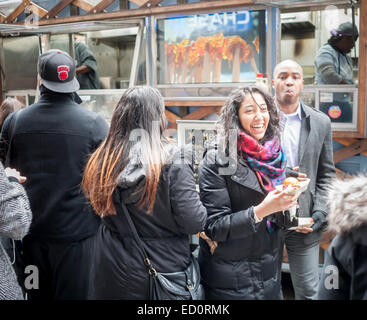 Des hordes d'amateurs queue à la Snowday chariot à New York le Mercredi, Décembre 17, 2014 pour célébrer la Journée nationale du sirop, le partenariat avec le sirop d'érable canadien, avec des échantillons gratuits de nombreux plats, y compris le sirop d'érable et au fromage de porc fumé-curseurs. Le camion alimentaire conscient socialement, partie de conduire le changement, exécute un programme utilisant l'anciennement incarcérées. (© Richard B. Levine) Banque D'Images