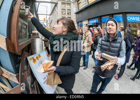 Des hordes d'amateurs queue à la Snowday chariot à New York le Mercredi, Décembre 17, 2014 pour célébrer la Journée nationale du sirop, le partenariat avec le sirop d'érable canadien, avec des échantillons gratuits de nombreux plats, y compris le sirop d'érable et au fromage de porc fumé-curseurs. Le camion alimentaire conscient socialement, partie de conduire le changement, exécute un programme utilisant l'anciennement incarcérées. (© Richard B. Levine) Banque D'Images