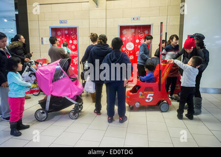 La foule des acheteurs de dernière minute pour attendre les ascenseurs dans le Queens Center Mall dans le borough du Queens à New York, le Super Samedi, 20 décembre 2014. Super Samedi, le samedi avant Noël était bondé avec les consommateurs et devrait générer plus de ventes que le Black Friday. (© Richard B. Levine) Banque D'Images