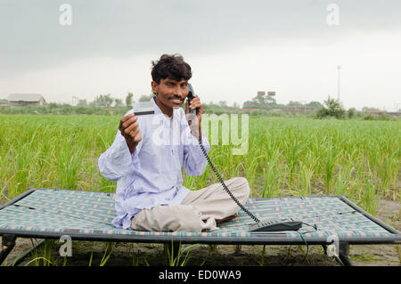 1 champ de l'homme rural indien avec carte de crédit Téléphone parlant Banque D'Images