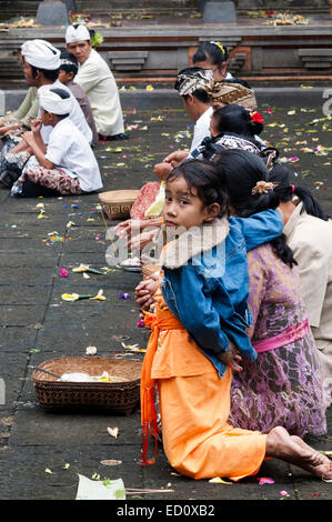 Une famille balinaise prie à PURA TIRTA EMPUL temple hindou et un complexe de sources froides - TAMPAKSIRING, BALI, INDONÉSIE. Plusieurs personnes Banque D'Images