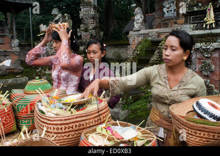 Une famille balinaise prie à PURA TIRTA EMPUL temple hindou et un complexe de sources froides - TAMPAKSIRING, BALI, INDONÉSIE. Plusieurs personnes Banque D'Images