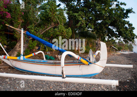 Un bateau repose sur la plage de sable d'Amed, un village de pêcheurs à l'Est de Bali. Amed est une longue bande côtière de villages de pêche en E Banque D'Images