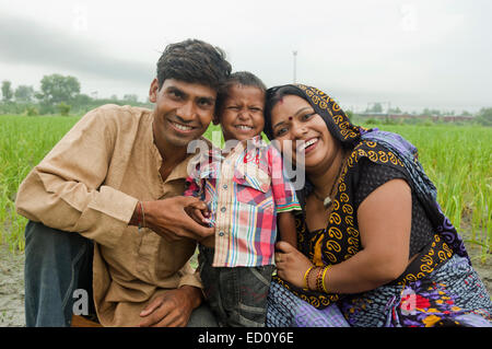 Les parents ruraux indiens et enfant assis farm Banque D'Images