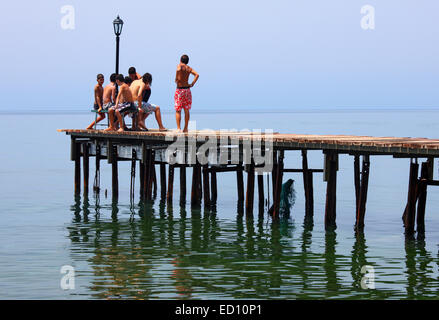 Une bande d'enfants s'amusant sur une chaude journée d'été sur la jetée de la ville de Molyvos, île de Lesvos, Grèce Banque D'Images