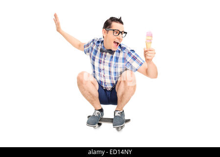 Young male sur un skate-board avec de la crème glacée Banque D'Images