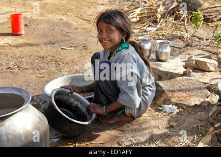 Petite fille de tribu Adivasi en pots nettoyage village près de Poshina, Gujarat, Inde Banque D'Images