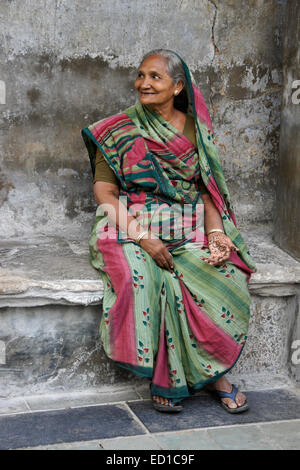 Femme assise à l'extérieur de la maison dans vieux Ahmedabad, Gujarat, Inde Banque D'Images