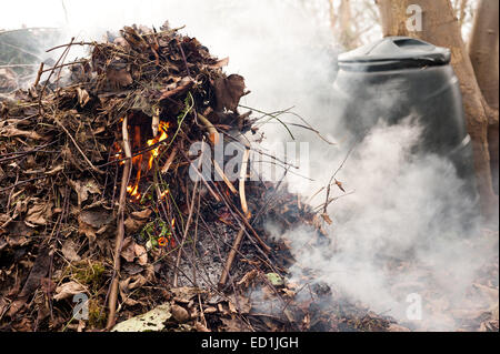 Feu de fumée se débarrasser des déchets de jardin feuilles boutures brindilles refuser provoquant des perturbations et à la pollution de l'air aux voisins Banque D'Images