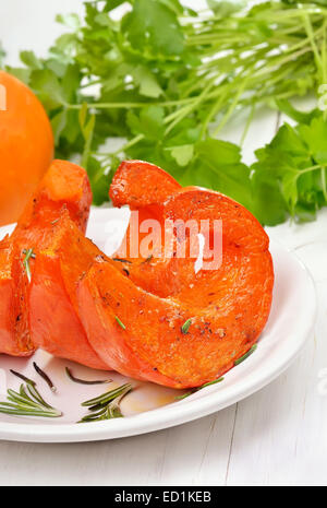 Tranches de citrouille rôties et légumes frais sur la table en bois blanc. La nourriture végétarienne. Banque D'Images