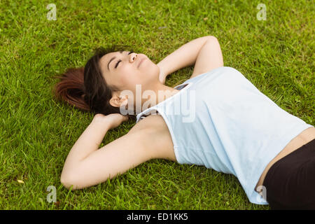 Healthy Woman lying on grass in park Banque D'Images