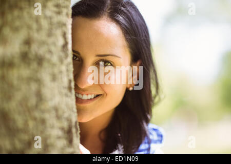 Portrait d'une jolie brune appuyé contre un arbre Banque D'Images