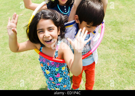 Les enfants indiens parc et jouent Hulahoop Banque D'Images