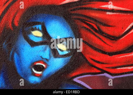 Graffiti sur un mur de la tête de femme bleu aux cheveux rouges Banque D'Images