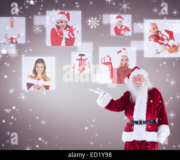 Image composite de santa montre quelque chose à l'appareil photo Banque D'Images