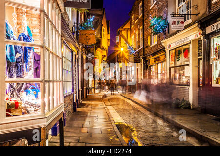 Noël dans la pagaille, la rue historique médiévale dans le vieux centre-ville de York, au crépuscule. Banque D'Images