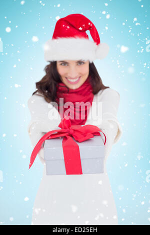 Image composite de brunette de fête à santa hat giving gift