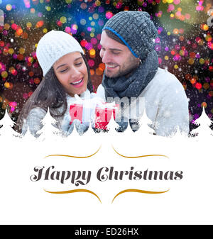 Image composite de l'hiver couple holding gift Banque D'Images