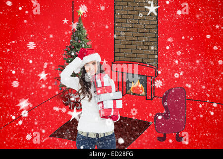 Composite image of brunnette in santa hat holding gifts Banque D'Images