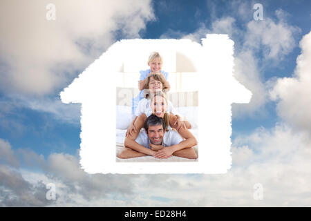 Image composite de happy family having fun sur un lit Banque D'Images