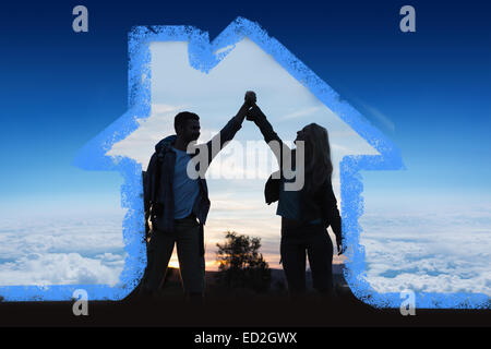 Image composite de silhouette couple holding up hands at Dusk Banque D'Images