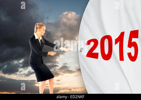 Composite image of blond businesswoman pulling a rope Banque D'Images