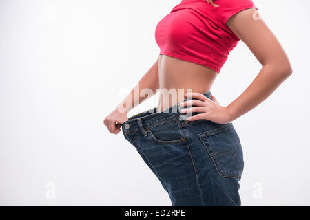 Taille fine de jeune femme en gros poids réussie montrant jeans Banque D'Images