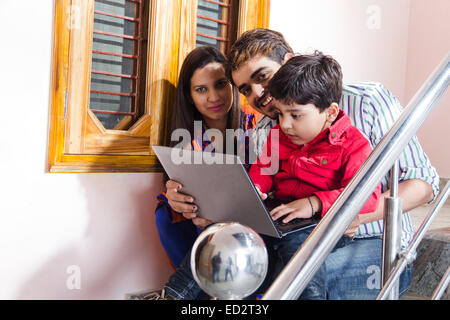 Les parents indiens et fils Accueil séance de travail portable et escalier Banque D'Images