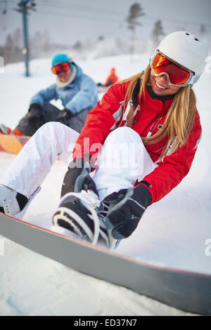 Female snowboarder en vêtements d'hiver sur resort Banque D'Images