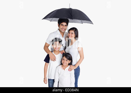 Les parents indiens et fils Protection Pluie parapluie Banque D'Images