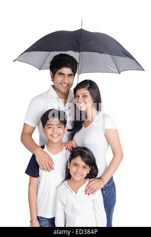 Les parents indiens et fils Protection Pluie parapluie Banque D'Images