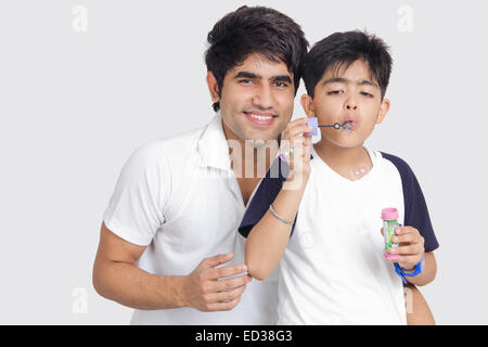 Père et fils indiens Blowing Bubble Wand Banque D'Images