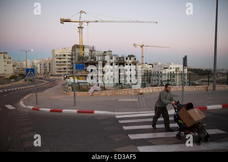 (141225) -- JÉRUSALEM, 25 décembre 2014 (Xinhua) -- File photo prise le 27 octobre 2013, montre un homme pousse une poussette de bébé pendant qu'il marche à côté d'un site de construction de logements dans la colonie israélienne de Har Homa, à Jérusalem-Est. Un comité de la municipalité de Jérusalem a approuvé le 24 décembre 2014, la construction de près de 400 nouveaux logements dans les colonies juives sur les terres annexées par Israël pendant la guerre de 1967 au Moyen-Orient. Le Comité de planification et de construction de Jérusalem le mercredi a approuvé 380 307 maisons dans l'ensemble, de qui sera situé dans le quartier nord-est de Ramot, et 73 maisons seront construites dans le Banque D'Images