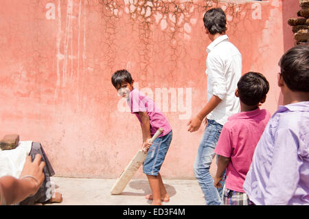 Groupe rural indien les enfants garçons à jouer au cricket Banque D'Images