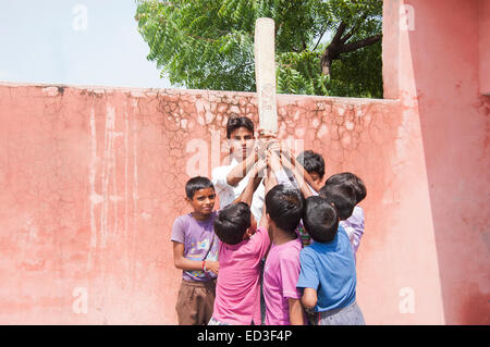 Groupe rural indien les enfants garçons à jouer au cricket Banque D'Images