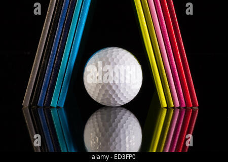 Douze couleurs différentes agendas et balle de golf sur un bureau en verre Banque D'Images