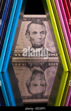 Douze couleurs différentes agendas et US dollar billet sur un bureau en verre Banque D'Images