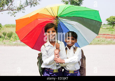 2 Les enfants ruraux indiens étudiants garçons holding Umbrella profitez de la saison des pluies Banque D'Images