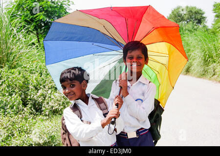 2 Les enfants ruraux indiens étudiants garçons holding Umbrella profitez de la saison des pluies Banque D'Images