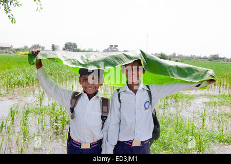 2 Les enfants ruraux indiens étudiants garçons holding Leaf profitez de la saison des pluies Banque D'Images