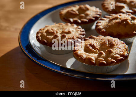 De plaque mince pies tourné contre la lumière sur une table en bois Banque D'Images