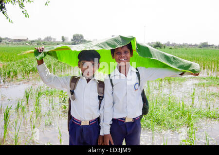 2 Les enfants ruraux indiens étudiants garçons holding Leaf profitez de la saison des pluies Banque D'Images