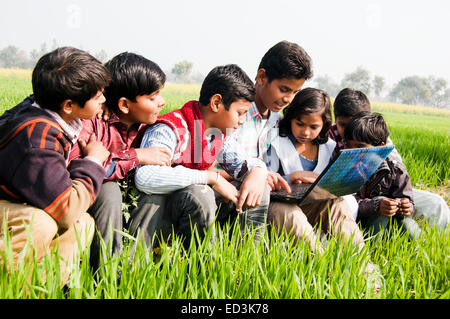 Les enfants ruraux indiens champ groupe profitez d'ordinateur portable Banque D'Images