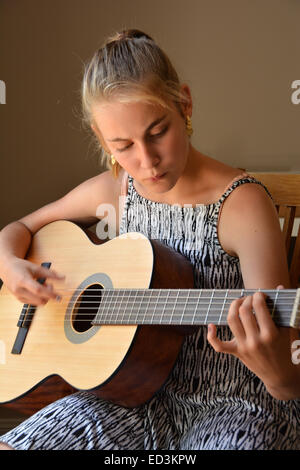 Teenage girl playing acoustic guitar Banque D'Images