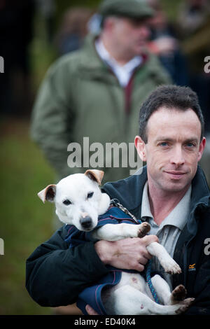 Man holding white dog comme bébé Staffordshire, Royaume-Uni. Dec 26, 2014. Boxing Day annuel rencontrez des Meynell et personnel du Sud Hunt au Blethfield Hall, Staffordshire Banque D'Images