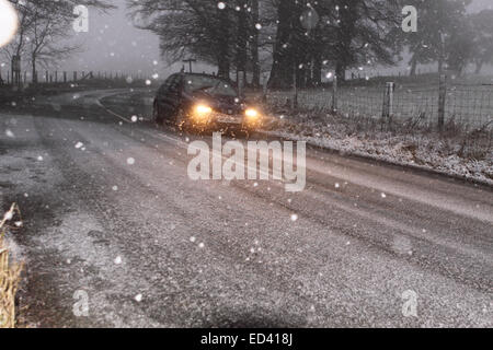 La conduite en hiver la neige commence à tomber sur les hauteurs entre Knighton et Presteigne sur le ungritted B4355 à 15h00 le lendemain de Noël 26 décembre 2014. Banque D'Images