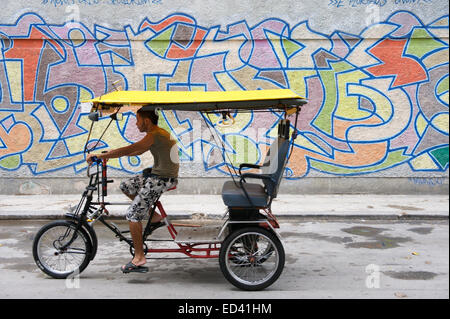 La HAVANE, CUBA - 18 MAI 2011 : Classic vélo taxi cubain durs le long d'une rue pittoresque dans le centre de La Havane. Banque D'Images