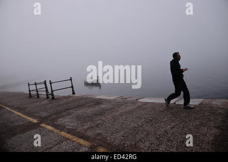 Un homme au cours de son footing matinal en front de mer de Thessalonique sous un épais brouillard, Grèce Banque D'Images